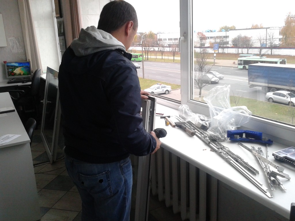 Мастер выполняет ремонт оконного блока